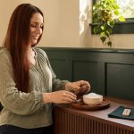 Salt as a Spiritual Tool: Meaning, Optional Rituals and Practical Care Woman beside a contained salt bowl, with a separate rune tile and notebook on a console